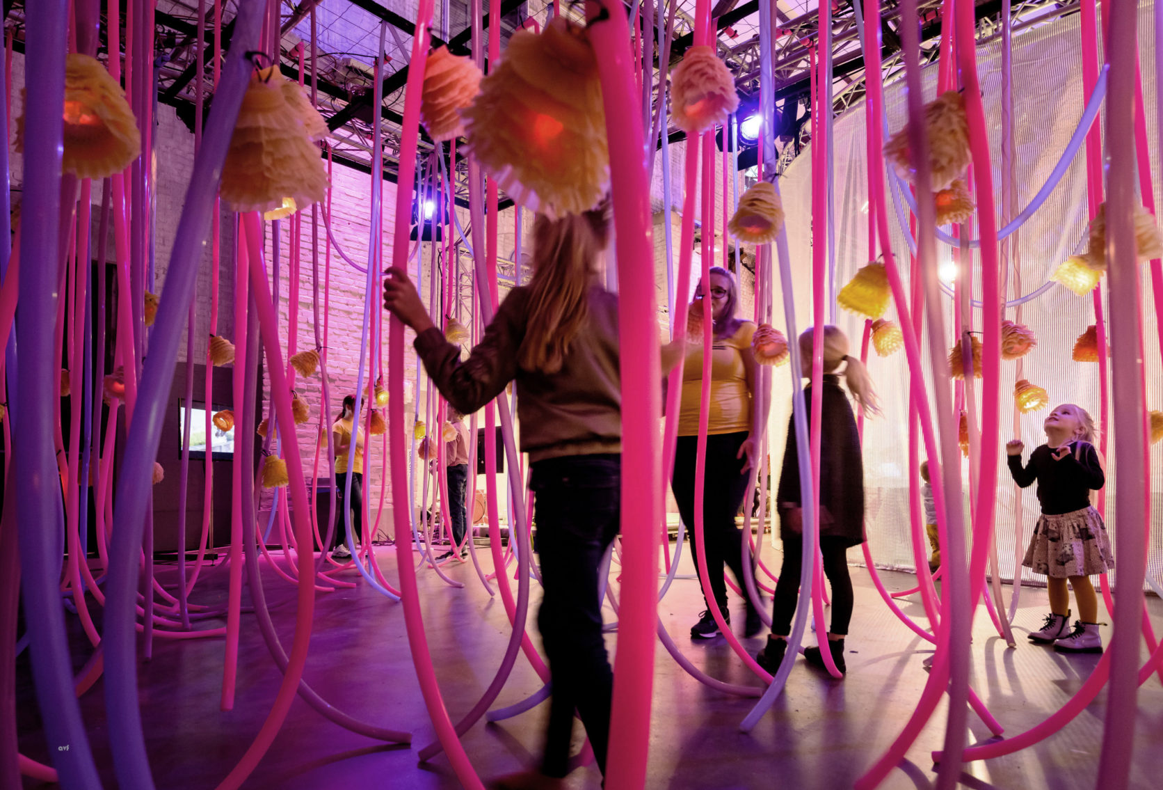 Children running through colored garlands